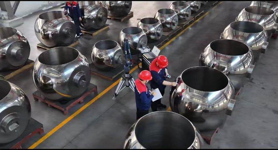 Large polished metal valve components are arranged on pallets inside the Zhejiang Haoqiu factory for production and inspection activities.