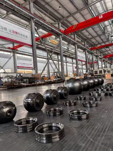 Rows of polished spherical metal components and circular machined rings are arranged across the floor of Zhejiang Haoqiu's factory.